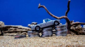 minahasa, Indonesia  January 2023, toy car on a pile of coins, saving for the future, managing successful transportation business technology concept photo