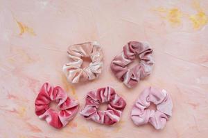 Collection of trendy velvet scrunchies on pink background photo