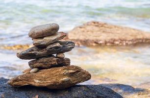 imagen de un rock en el costa de el mar ellos son apilado hermosamente en secuencia, todavía ver isla y cielo claro, Mira relajado. adecuado relajarse y viaje Khao aprender ya nacional parque Rayong Tailandia foto