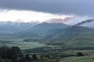 First rays of sunlight of the day shine through the mist on the mountain photo