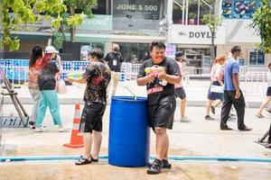 Siam Square, Bangkok, Thailand - APR 13, 2023 Songkran Festival, The short action of people joins celebrations of the Thai New Year or Songkran in Siam Square Bangkok, Thailand. photo