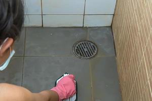 Woman cleaning bathroom floor photo