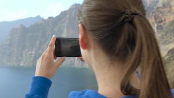 mujer toma foto de los gigantes acantilados en tenerife, canario islas, España video