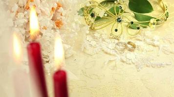 Wedding rings with candles and flowers video