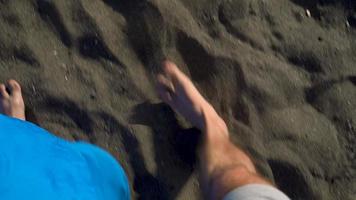 Haut vue de couple ambulant ensemble à le noir volcanique le sable à océan plage video