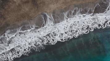 topp se av de öken- strand på de atlanten hav. kust av de ö av teneriffa. antenn Drönare antal fot av hav vågor nå Strand video