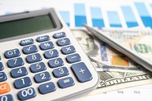 Pen and calculator on chart or graph paper. Financial, account, statistics and business data concept. photo