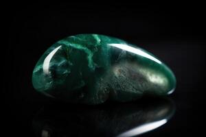 Jade is a rare precious natural geological stone eremite on a black background in low key. . photo