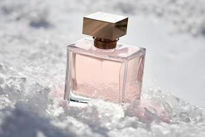 Perfume bottle in the snow, winter, fresh cold fragrance concept. Neural network generated art photo