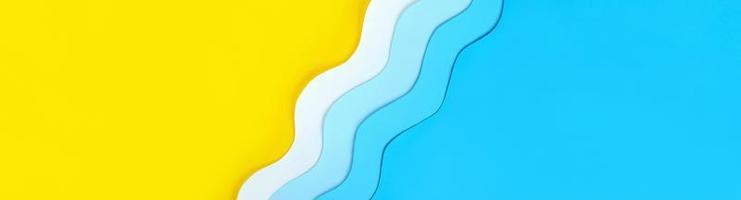 Summer holidays long banner with seashore diagonal background made of color paper. Yellow beach sand with copy space and paper cut out blue waves. Relaxation on vacations. The ocean coast layout. photo