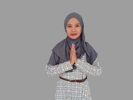 Portrait of a young beautiful Asian Muslim woman wearing a hijab gesturing Eid Mubarak greeting photo