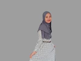 Young Asian Muslim woman wearing hijab smiling to the camera, isolated by grey background photo