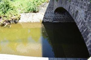 minúsculo río debajo un Roca puente foto