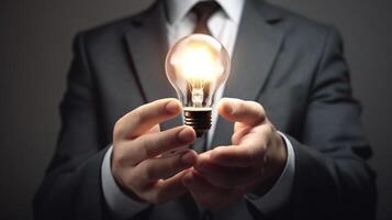 Businessman holding a glowing lightbulb in his hand. Business and innovation concept. photo