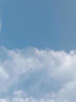 White clouds in the blue sky. Beautiful bright blue background. Light cloudy, good weather. Curly clouds on a sunny day. photo