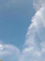 White clouds in the blue sky. Beautiful bright blue background. Light cloudy, good weather. Curly clouds on a sunny day. photo