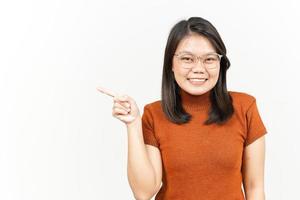 mostrando el producto y apuntando hacia el lado de una hermosa mujer asiática aislada de fondo blanco foto