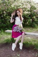 A fashionable girl with dark hair, a spring portrait in lilac tones in summer. Bright professional makeup. photo