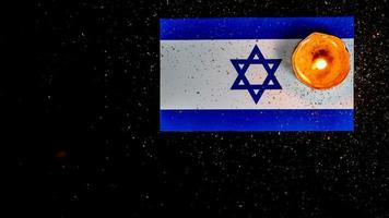 bandera israelí y velas ardiendo sobre ella, día de la memoria del holocausto foto