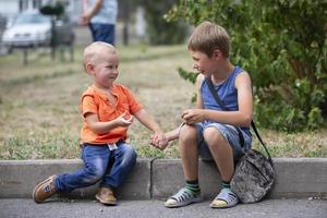 Two brothers, younger and older, are playing on the street. photo