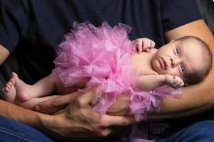 Newborn baby in the arms of her dad. Beautiful little child photo