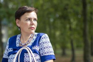 Ordinary middle-aged woman in the park.The woman is fifty years old. photo