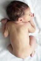 Newborn naked baby from above close-up.The child is seven days old. photo