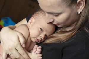 el recién nacido niña aferrado a su madre. joven mujer con un bebé. foto