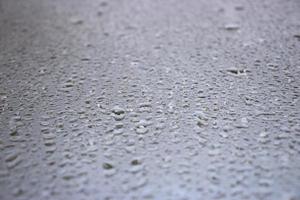 Close-up view on water drops on window in rain. Drops of rain on the glass concept photo. Front view photography with blurred background. photo