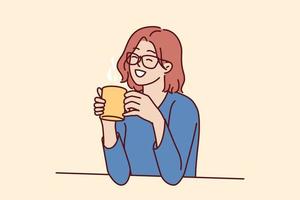 Joyful woman holding coffee mug sitting at table and smiling remembering happy moments from life during lunch break. Girl in casual clothes drinks hot tea or coffee to gain vigor and energy vector