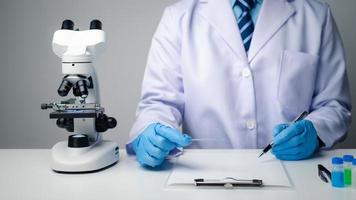 Close up view of scientist researcher taking note while testing substances in laboratory. photo