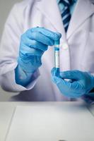 Close up view of scientist researcher showing tube glass equipment while testing substances in laboratory. photo