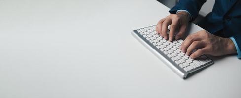 Young professional businessman typing on keyboard computer with copy space. photo