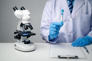 Close up view of scientist researcher showing tube glass equipment while testing substances in laboratory. photo