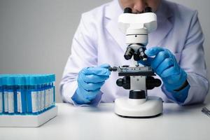 profesional científico utilizando microscopio mientras trabajando en médico investigación en Ciencias laboratorio. foto