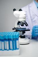 Professional scientist using microscope while working on medical research in science laboratory. photo