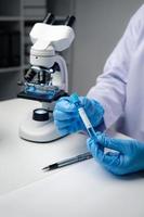 Close up view of scientist analyzing a liquid in the test tubes in laboratory. photo