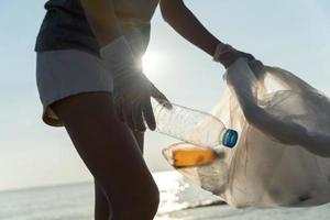 ahorrar agua. los voluntarios recogen basura en la playa y las botellas de plástico son difíciles de descomponer para evitar dañar la vida acuática. tierra, ambiente, planeta verde, reducir el calentamiento global, salvar el mundo foto