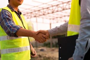 Construction worker team hands shaking greeting start up plan new project contract in office center at construction site, industry ,architecture, partner, teamwork, agreement, property, contacts. photo