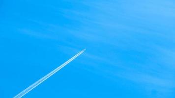 Contrails in the blue sky. Airplane flying high. Slow motion video