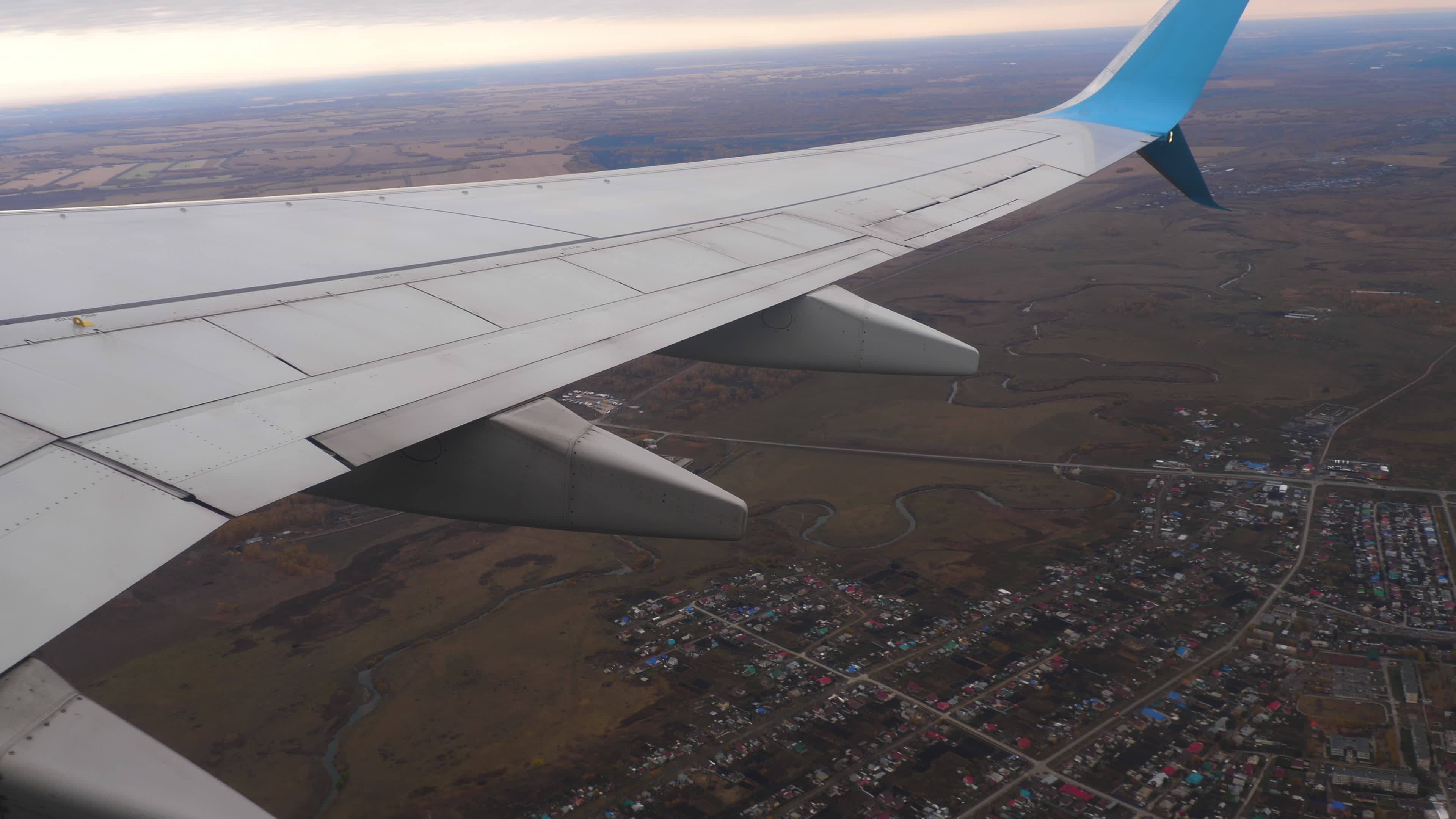 View from the porthole on the wing, flight. Fly over beautiful fields