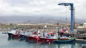 Visão do colorida barcos ancorado dentro marina e montanhas coberto com nuvens em a fundo video