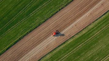 Aerial view of tractor performs seeding on the field video