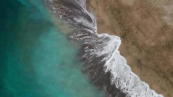 parte superior ver de el Desierto playa en el atlántico océano. costa de el isla de tenerife aéreo zumbido imágenes de mar olas alcanzando apuntalar video