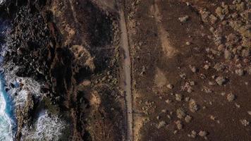 Aerial view of woman runs along the oceanfront nature reserve at sunrise. Healthy active lifestyle video