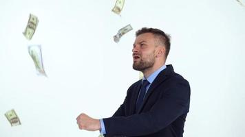 Slow motion of formally dressed man is delighted with the fact that a lot of dollar bills are fall on him video