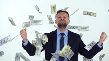 Slow motion of formally dressed man is delighted with the fact that a lot of dollar bills are fall on him video