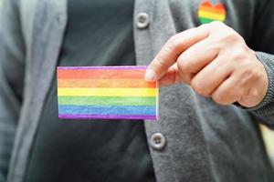 mujer asiática con bandera del arco iris, derechos de símbolos lgbt e igualdad de género, mes del orgullo lgbt en junio. foto