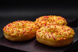 Delicious fresh donuts in yellow glaze with lemon flavor filling photo