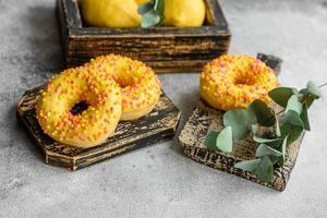 Delicious fresh donuts in yellow glaze with lemon flavor filling photo